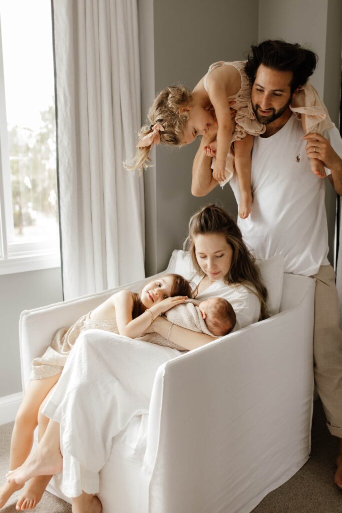 A family embracing each other around their new baby.