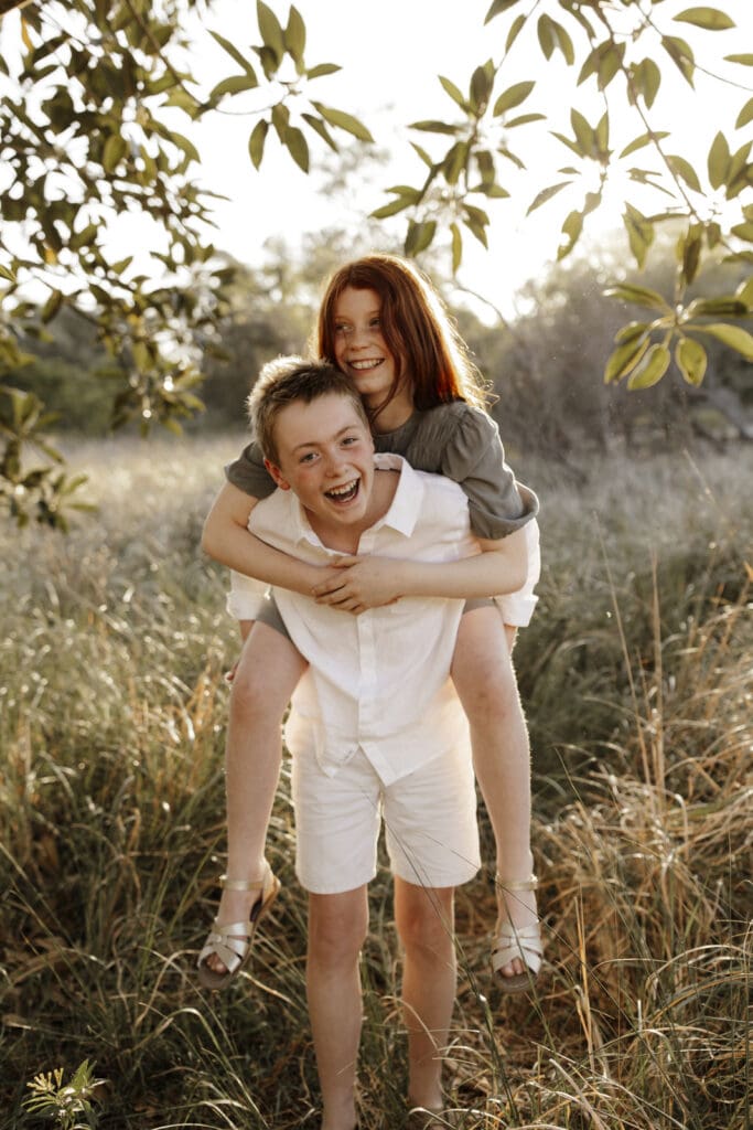 family photography captures siblings on each others back